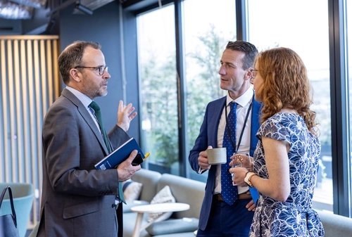 Guy Thompson talking to two colleagues